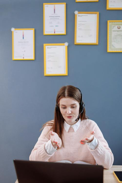 A medical sales representative connecting with a client online while showcasing their certifications on the wall.