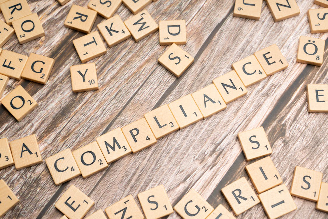 "Compliance” written with scrabble blocks