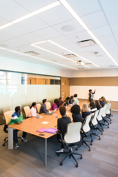 A female expert giving training to medical sales representatives, sitting in a conference room