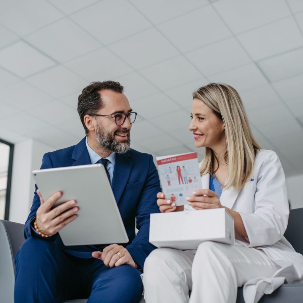 a man in a blue suit and woman in a white suit looking at documents