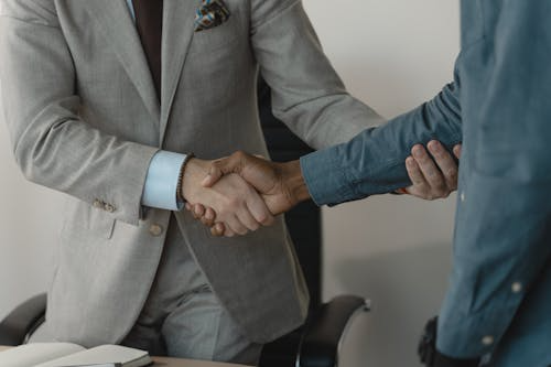 recruiter shaking hands with a candidate during a medical device sales hiring discussion, symbolizing successful talent acquisition